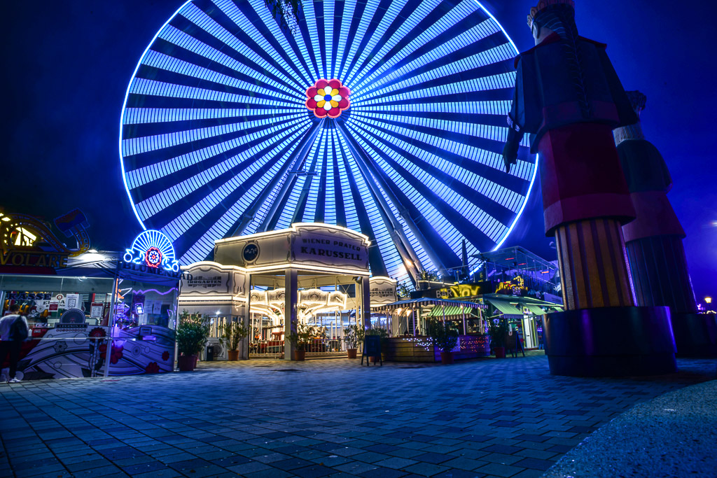 Riesenrad blau beleuchtet mit Eingangsgebäude