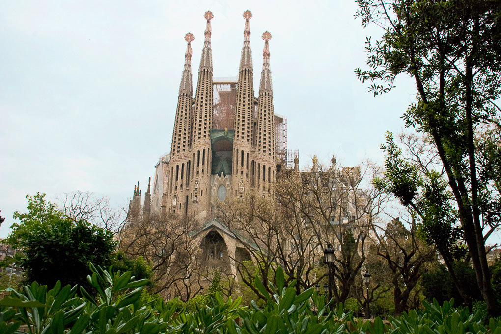 Sagrada Família mit ihren Türmen hinter Bäumen