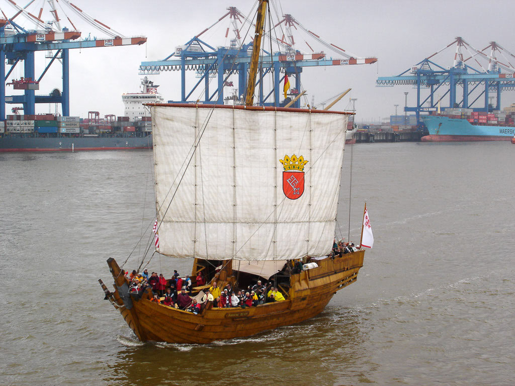 Kleines Holzschiff vor dem Containerterminal