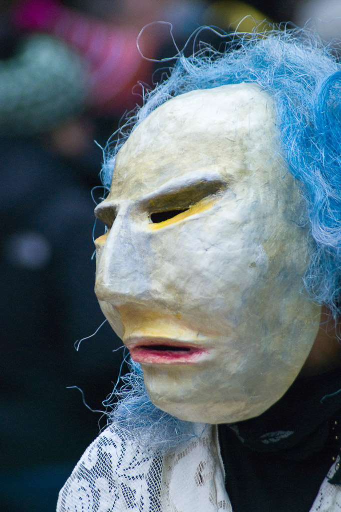 Weiße Maske vor blauem Haar