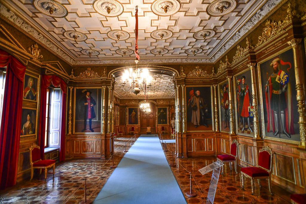 Saal mit Gemälden und Teppich