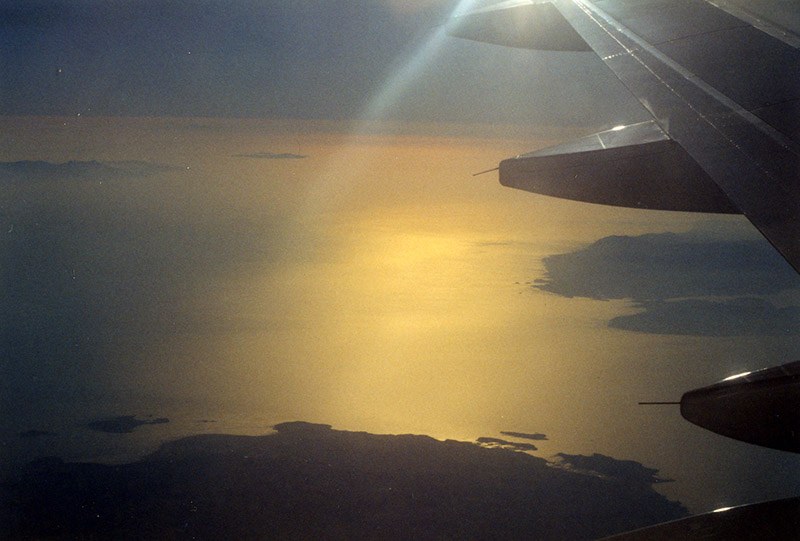 Blick aus dem Flugzeug über das Meer im Gegenlicht