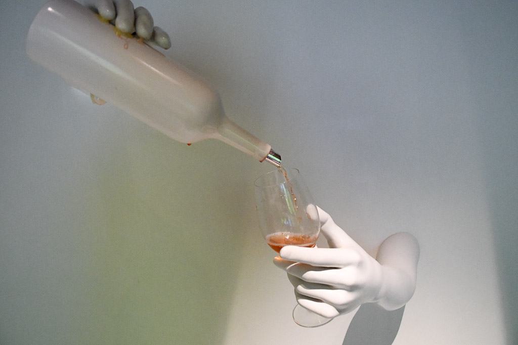 Hand mit einer Weinflasche, die Wein ausschenkt