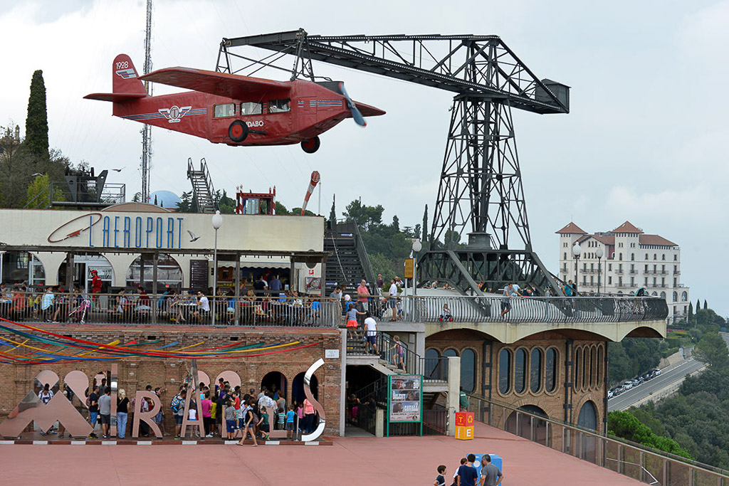 Rotes Flugzeug-Fahrgeschäft vor einem Kran