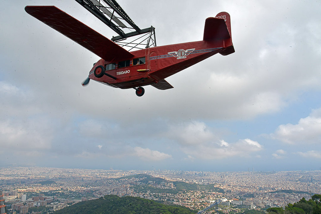 Rotes Flugzeug-Fahrgeschäft über der Stadt