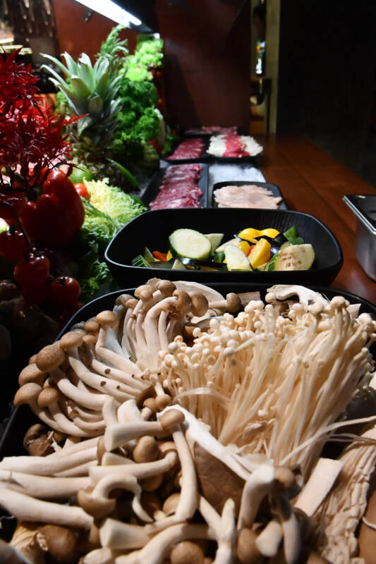Fleisch, Gemüse und Pilze am Grillbuffet im Hochformat