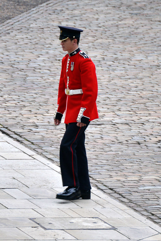 Gardist in roter Uniform auf dem Pflaster im Hochformat