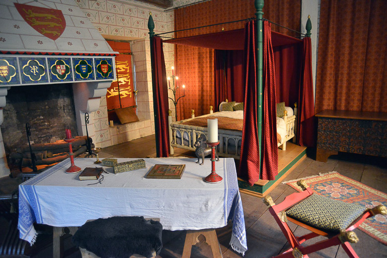 Mittelalterliches Schlafzimmer mit Tisch und Himmelbett