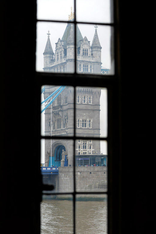 Blick durch ein Fenster auf die Tower Bridge im Hochformat