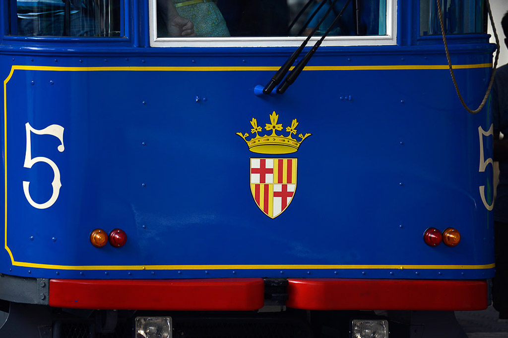 Frontansicht der blauen Straßenbahn mit Nummer 5 und Wappen