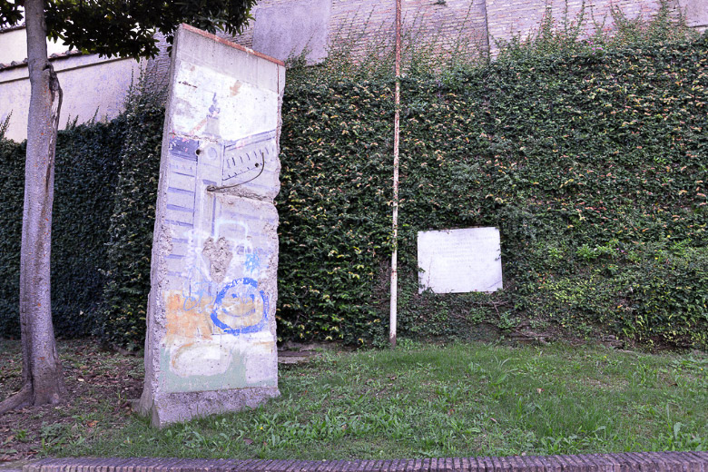 Teilstück der Berliner Mauer im Garten im Hochformat