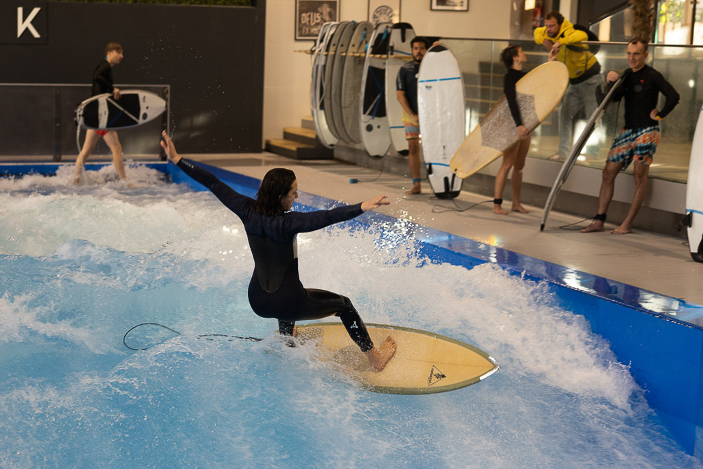 Person auf dem Surfbrett vor dem Wasserbecken