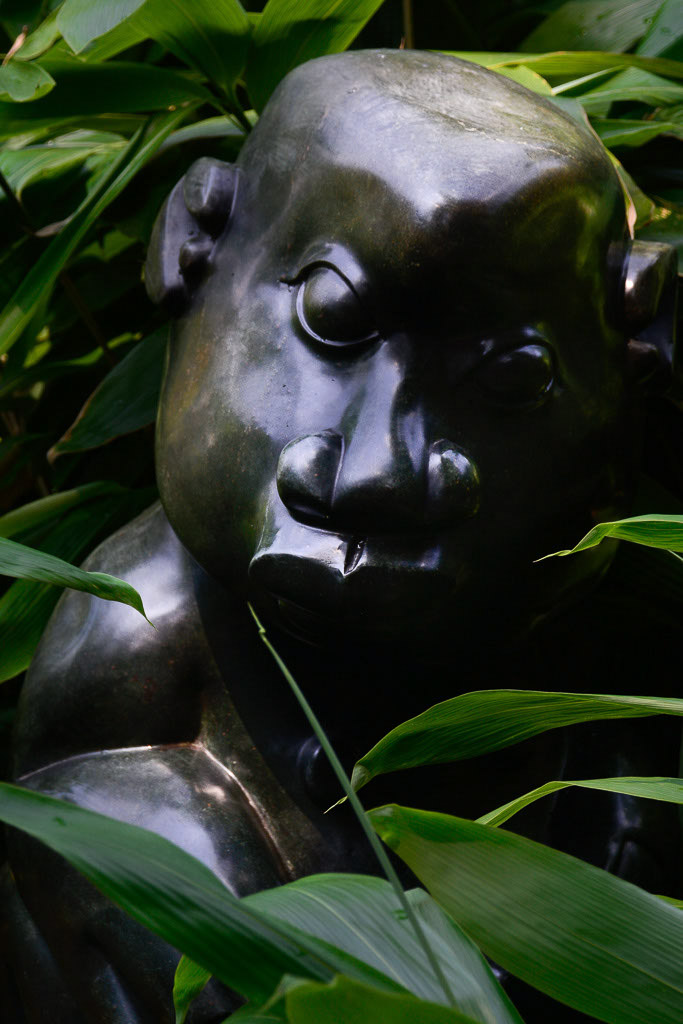 Bronzefigur im Grün im Hochformat