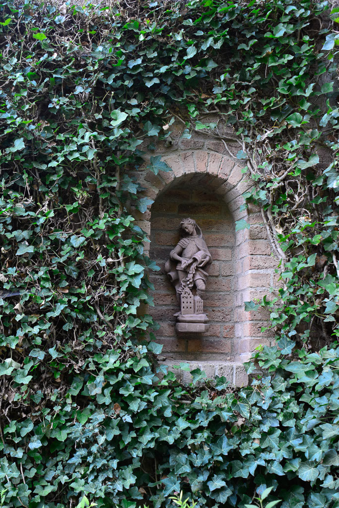Figur in einer Mauernische im Hochformat