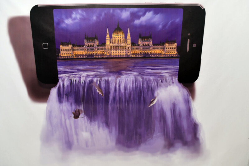 Smartphone vor einem gemalten Wasserfall, auf dem das Parlament zu sehen ist
