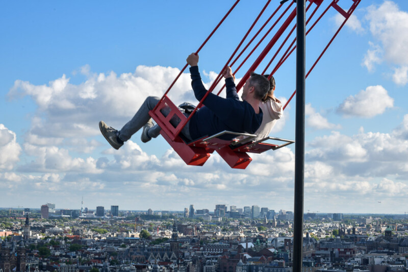 Besucher auf der Schaukel Over The Edge hoch über Amsterdam