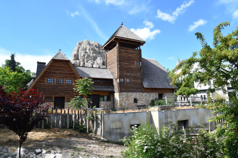 Holzhaus im Zoo vor Felsen