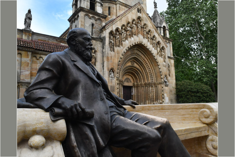Statue des Anonymus vor einem Kirchenportal