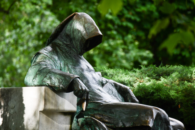 Statue des Anonymus mit Kapuze und Umhang