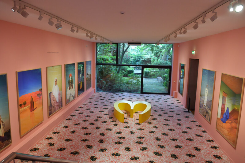 Heller Ausstellungsraum im Foam mit Porträts und einer gelben Sitzskulptur
