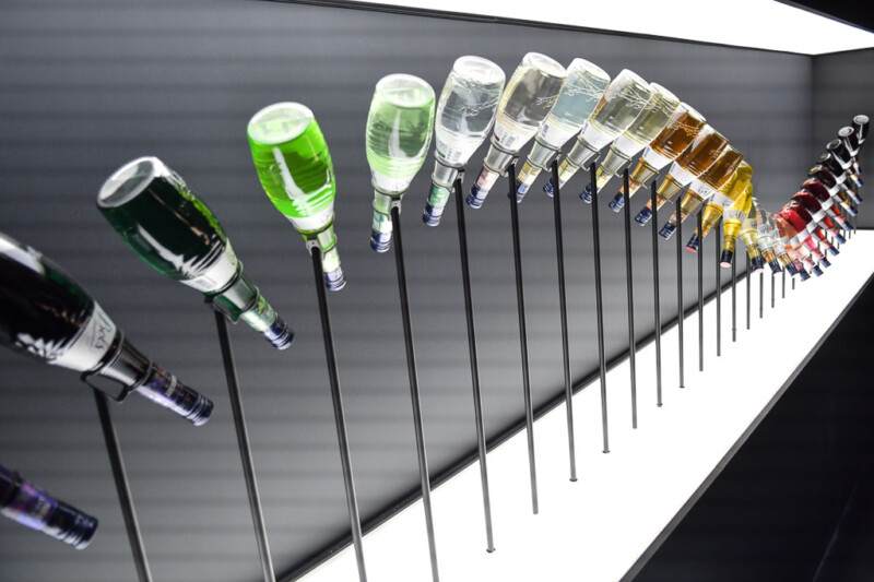 Reihe von Likörflaschen an einer schwarzen Wand im House of Bols