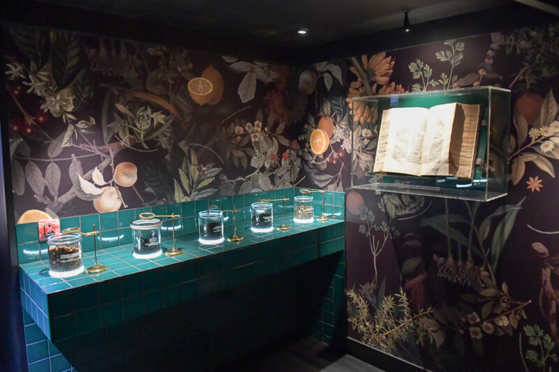 Vitrine mit historischem Buch vor gemusterter Tapete im House of Bols