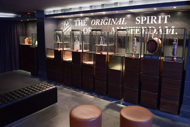Raum mit Vitrinen und Sitzhockern zum Thema Genever im House of Bols