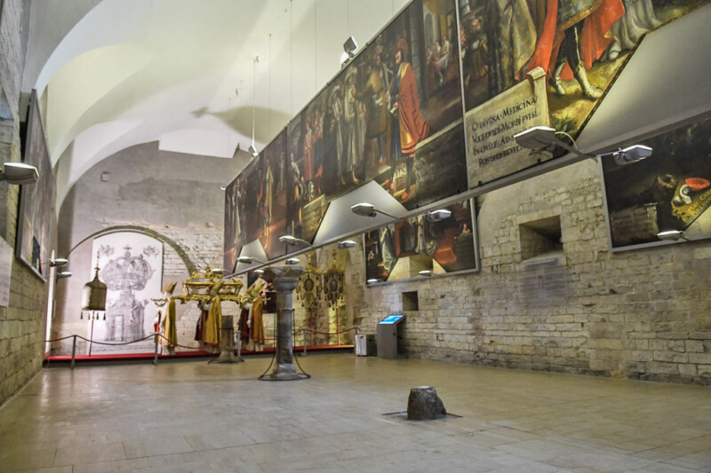 Ausstellungsraum mit Gemälden und Gewölbe
