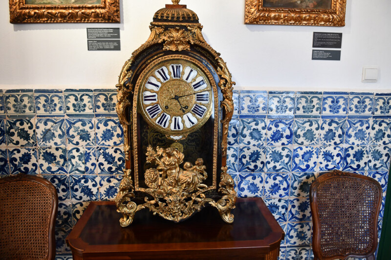 Verzierte Standuhr vor Azulejos