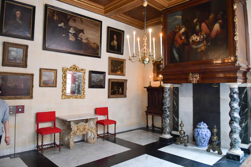 Salon mit Gemälden, rotem Gestühl und Kronleuchter