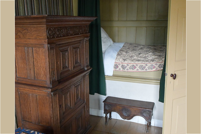 Schlafnische mit Bett und Teppich im historischen Wohnraum