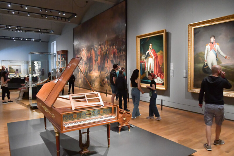Saal mit Flügel und Porträtgemälden im Rijksmuseum