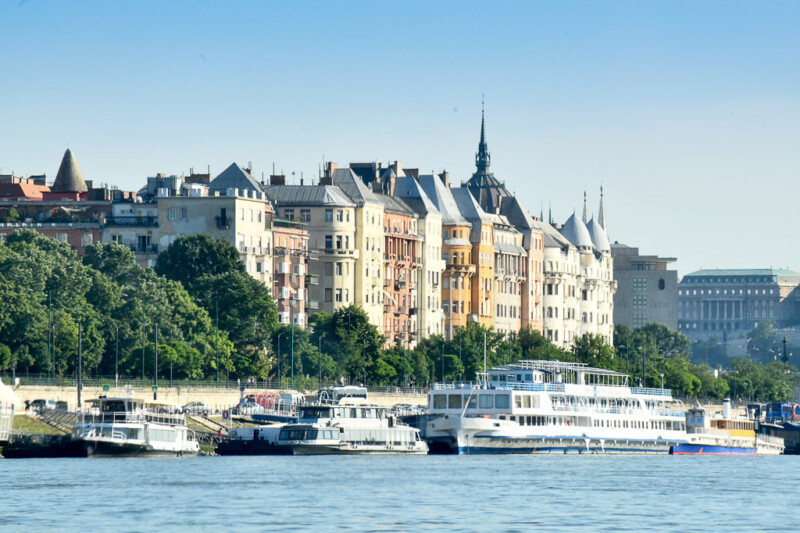 Gebäudereihe am Donauufer mit Ausflugsschiffen