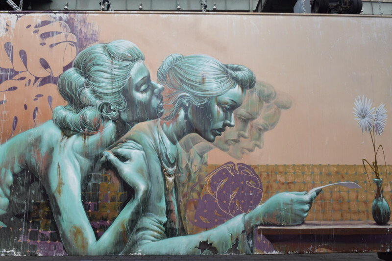 Wandbild mit zwei Frauenfiguren in Türkistönen