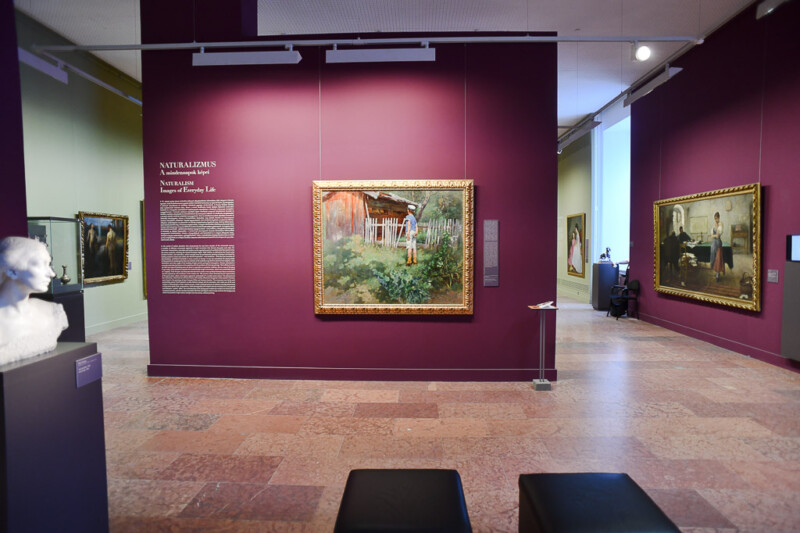 Saal mit Gemälden vor violetten Wänden