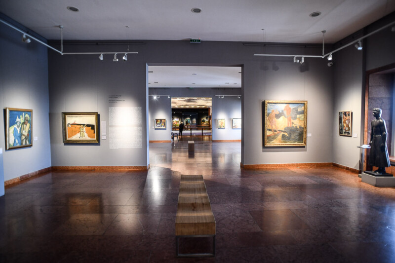 Ausstellungssaal mit Gemälden und Durchgang
