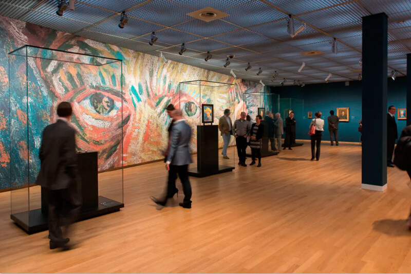 Besucher in einer Ausstellungshalle des Van Gogh Museums vor einer großformatigen Wandgestaltung