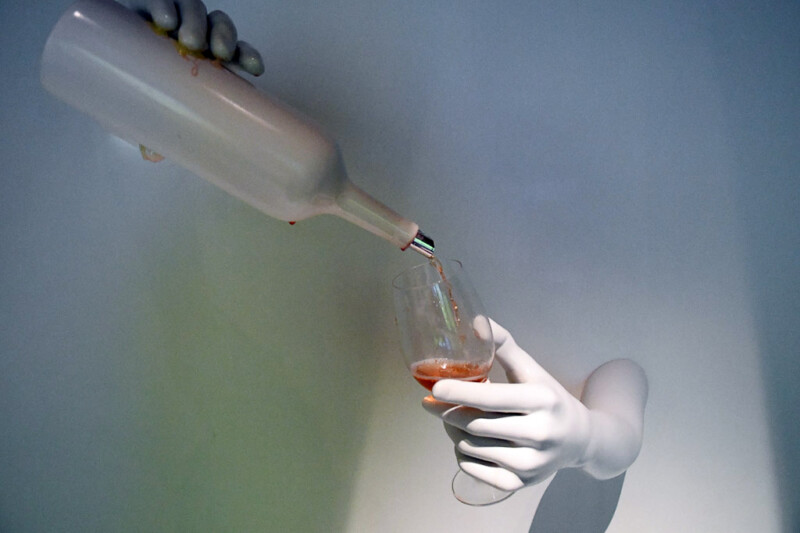 Hand mit einer Weinflasche, die Wein ausschenkt